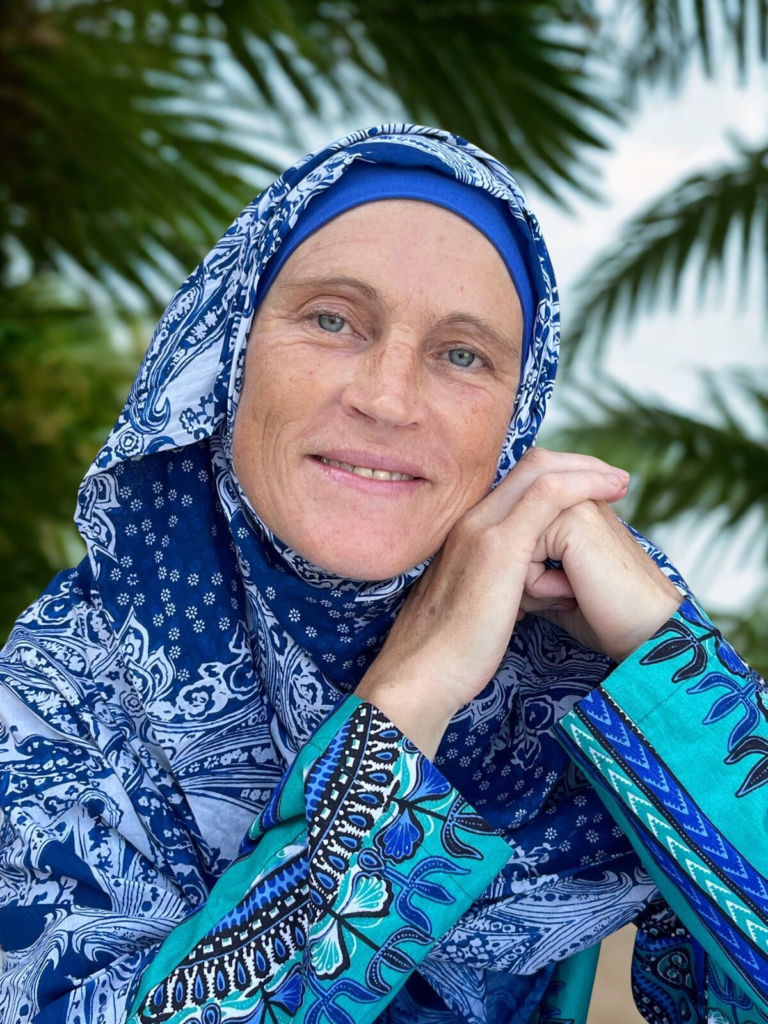 Ilya Umm Bilaal, trauma-informed transformational coach for Muslim women, smiling at the camera.