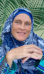 Ilya Umm Bilaal, trauma-informed transformational coach for Muslim women, smiling at the camera.